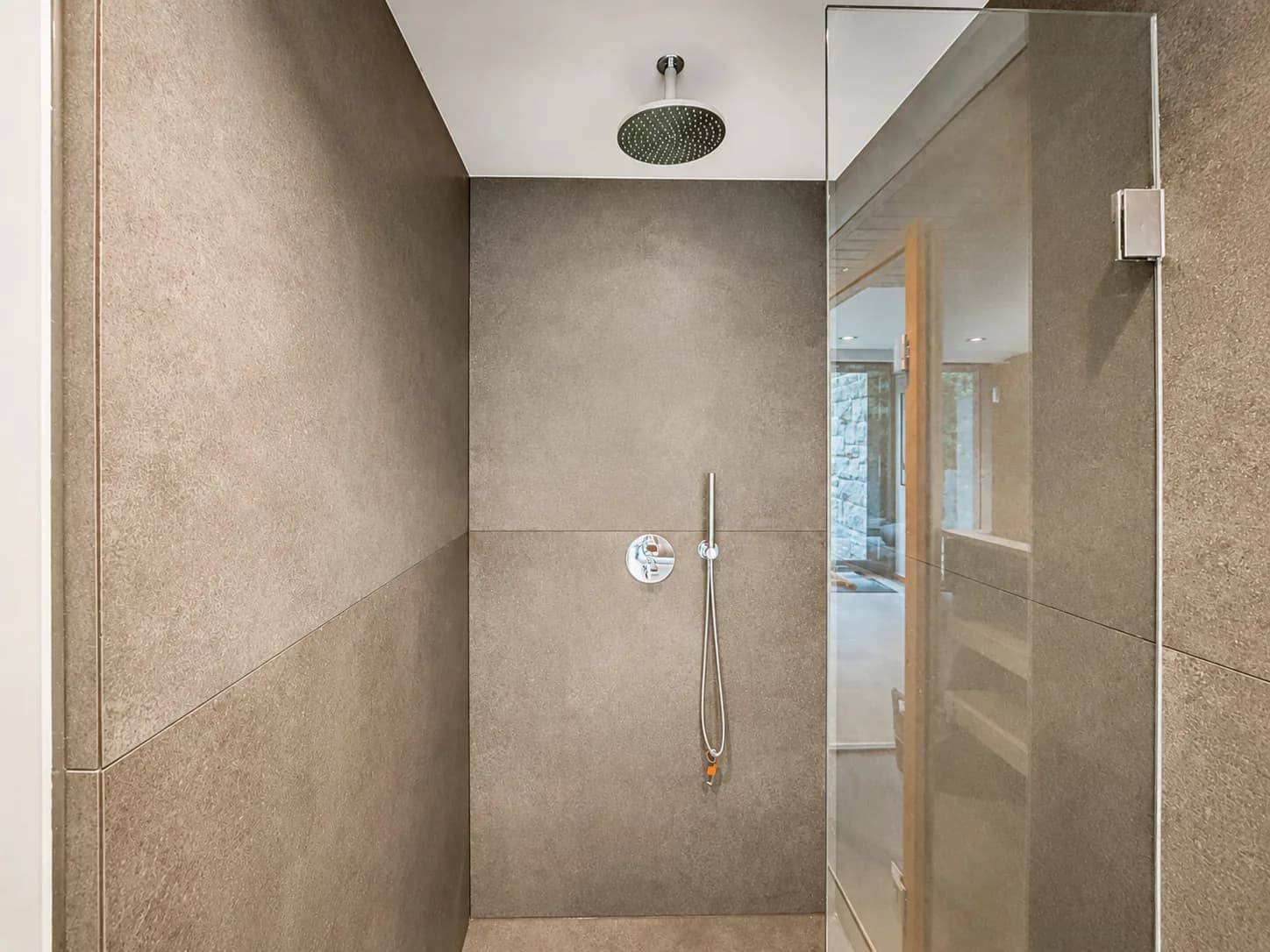 Ebenerdige Dusche mit Regenbrause in Natursteinoptik hinter Glaswand, Hartenfels