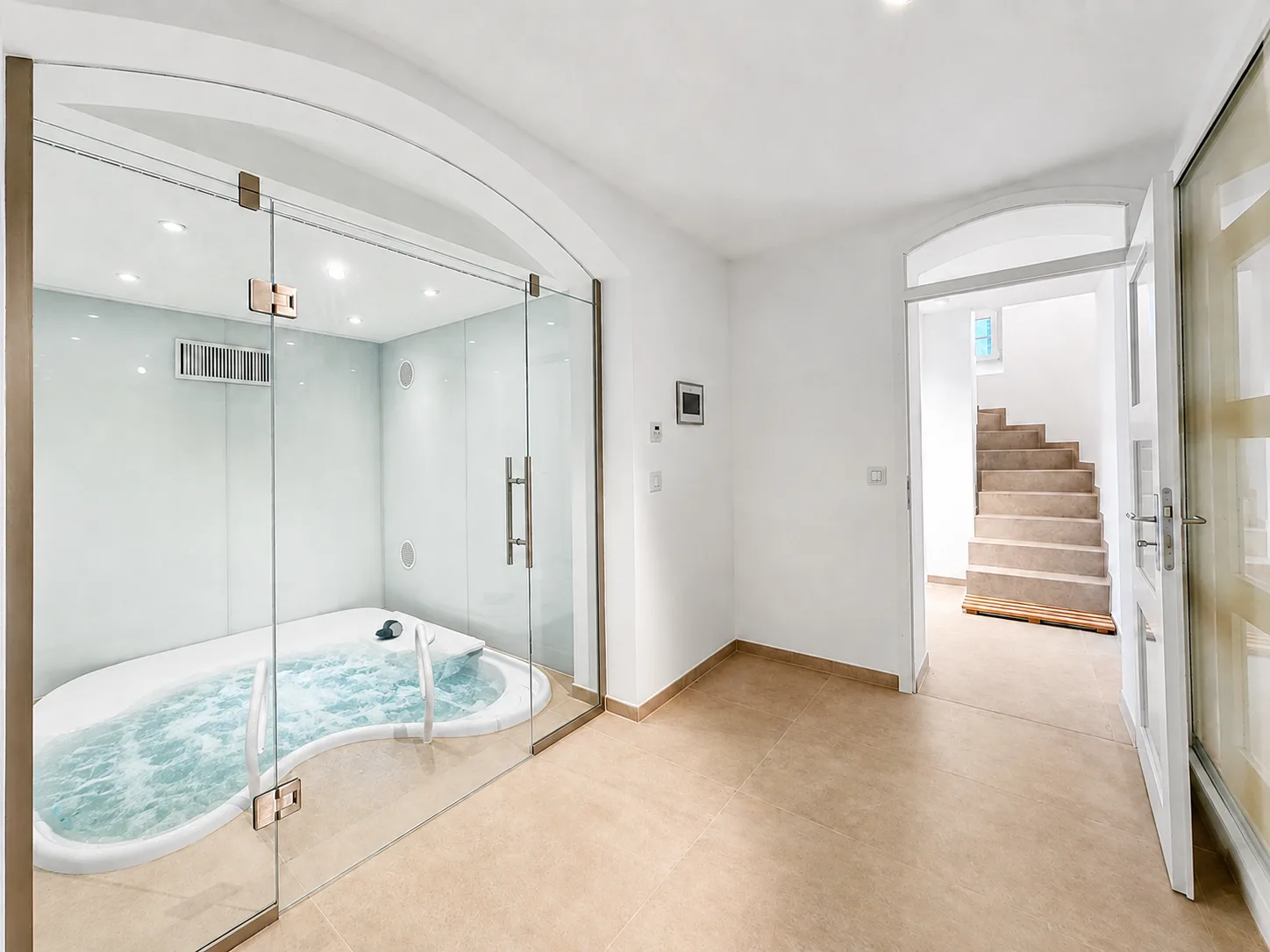 Sprudelnder Whirlpool hinter Glas unter gewölbter Decke, daneben der Treppenaufgang, Hartenfels